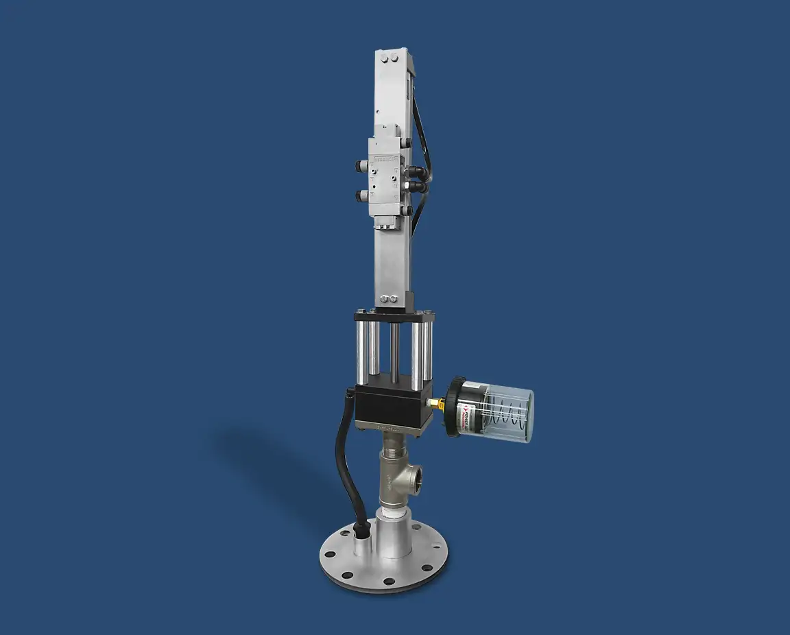 An industrial machine component with a cylindrical base, vertical metal column, and attached rectangular and cylindrical parts features a top-head drive pump. The device has various connectors and wiring, all set against a solid blue background.