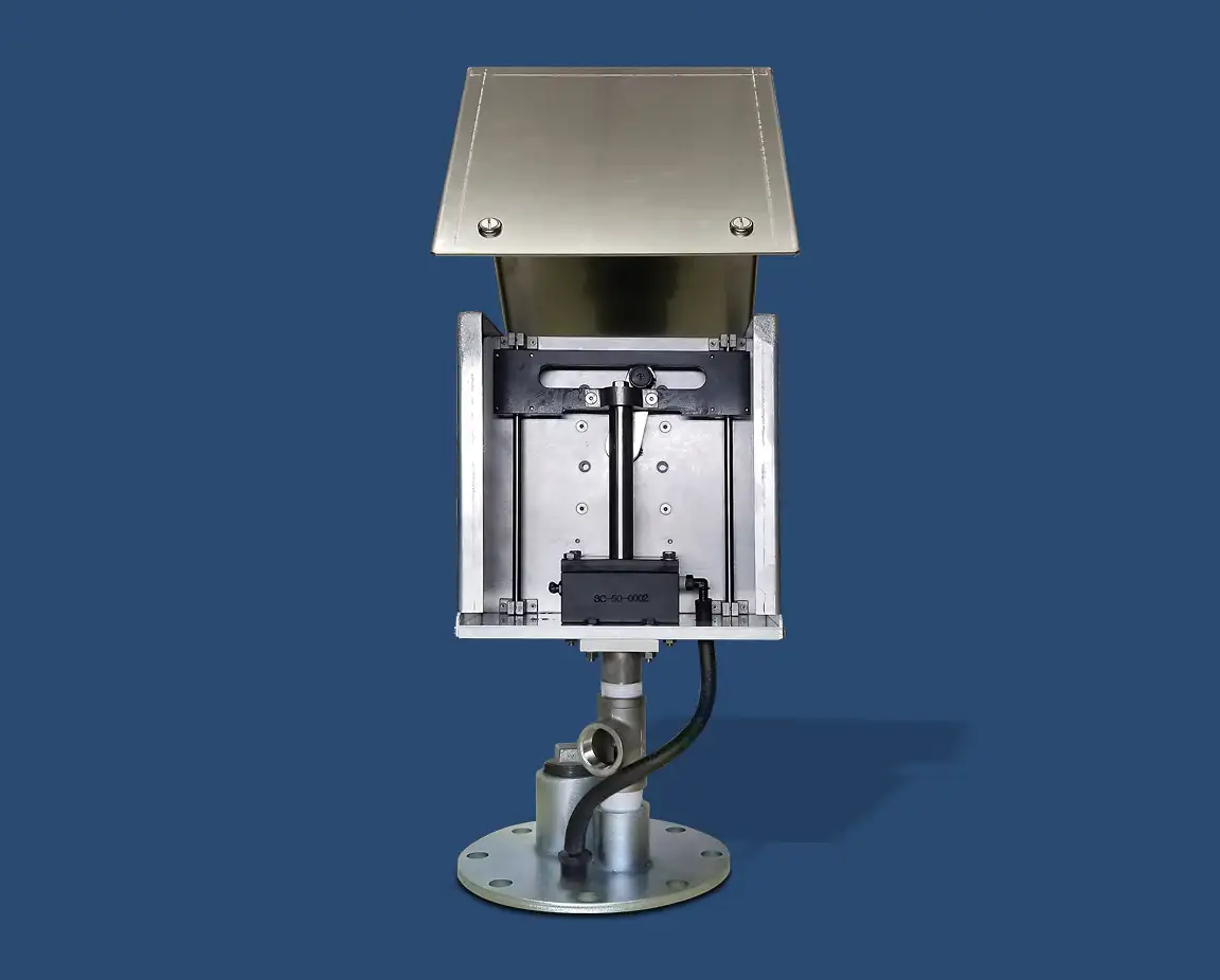 A stainless steel industrial device with a rectangular box and an angled top cover mounted on a metallic base. The device features an adjustable mechanism inside, linked to a top-head drive pump by wiring, set against a blue background.